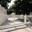 Portail coulissant sur clôture à barres blanche, clôture à barres finition ferronnerie d'art devant une grande entrée