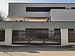 [Translate to Fransösich:] Schiebetor im Stil eines Lattenzauns mit Schrägkappen vor einer Einfahrt eines modernen Einfamilienhauses