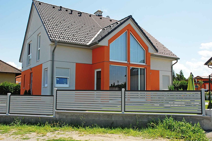 Clôture occultante - clôture à lattes bicolore avec lattes transversales grises devant une maison style années 90