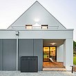 coffre multifonctions moderne couleur anthracite devant une maison unifamiliale moderne avec toit pointu et terrasse