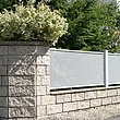 Clôture de jardin blanche en tôle perforée sur socles muraux avec briques et plantes