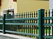 Vue rapprochée d'une clôture à barres couleur vert mousse en aluminium finition ferronnerie d'art avec ornements