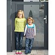 deux jeunes filles se tenant sur un portillon en tôle perforée à l'entrée de la maison