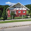 Clôture en anthracite devant une maison en blanc et rouge avec un grand jardin 
