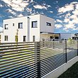 clôture de jardin moderne avec lattes transversales couleur anthracite devant une maison à architecture moderne