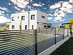 clôture de jardin moderne avec lattes transversales couleur anthracite devant une maison à architecture moderne